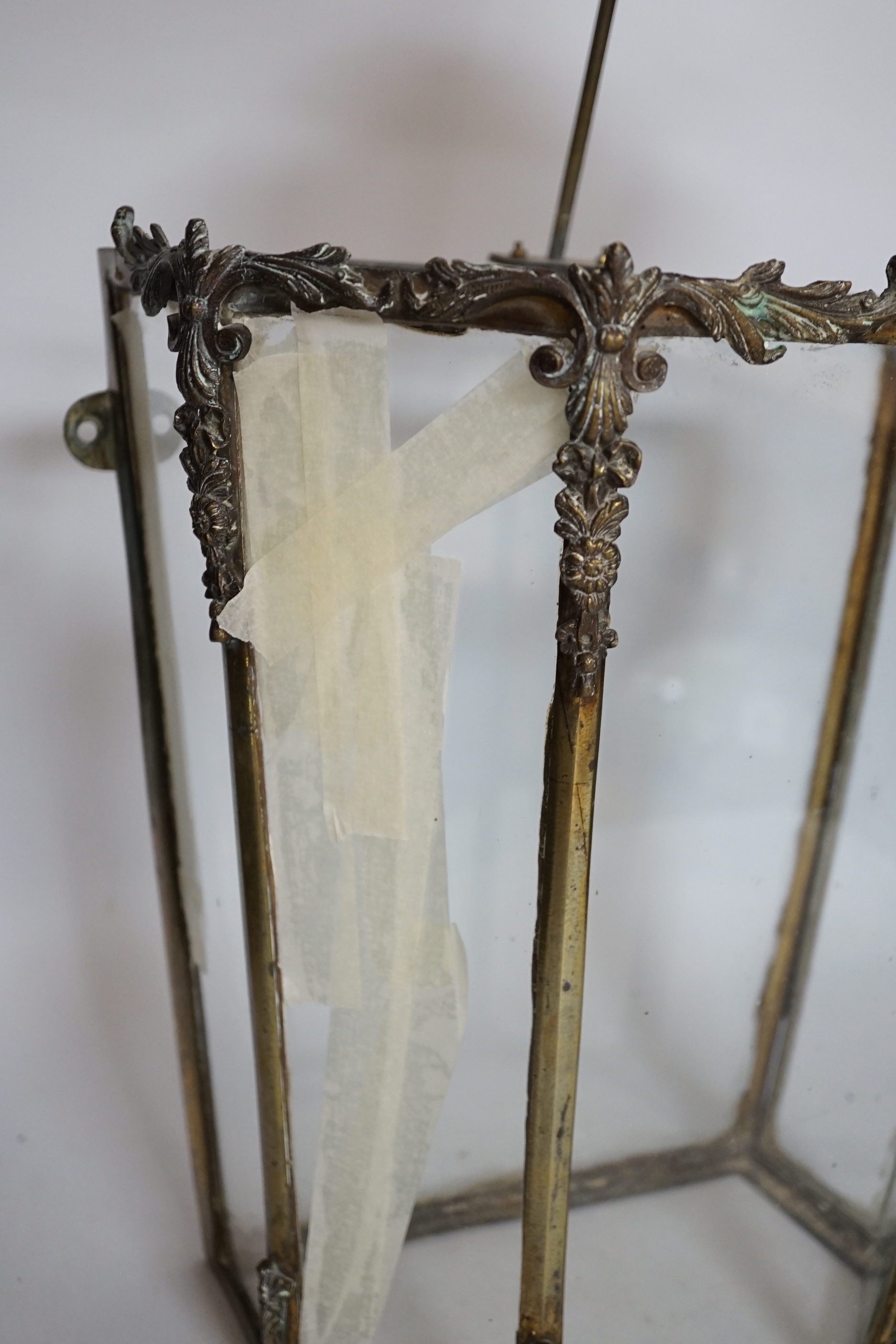 A 19th century brass framed porch lamp with applied scrolled decoration, 65cm high